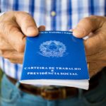 Homem segura carteira de trabalho (Shutterstock)